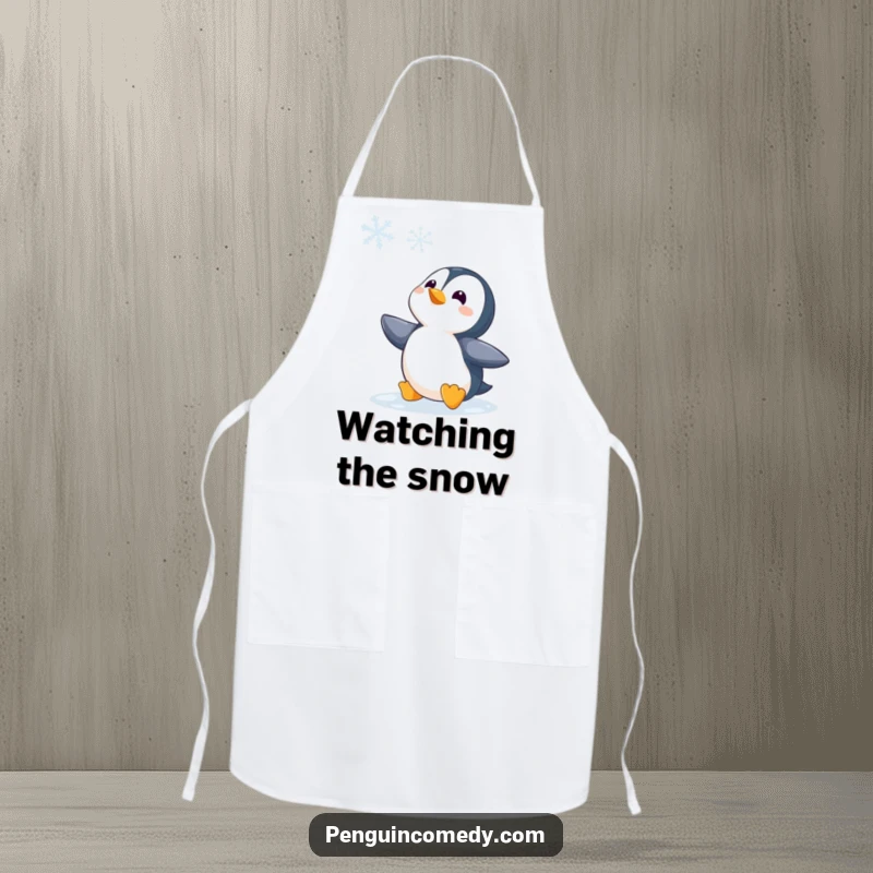 Funny Penguin Watching Snowflake Apron, a humorous kitchen accessory showing a penguin captivated by a snowflake, ideal for cozy cooking moments.