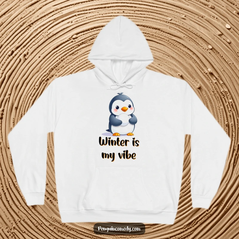 Funny hoodie depicting a delightful penguin clutching a small snowball, ready for winter amusement.