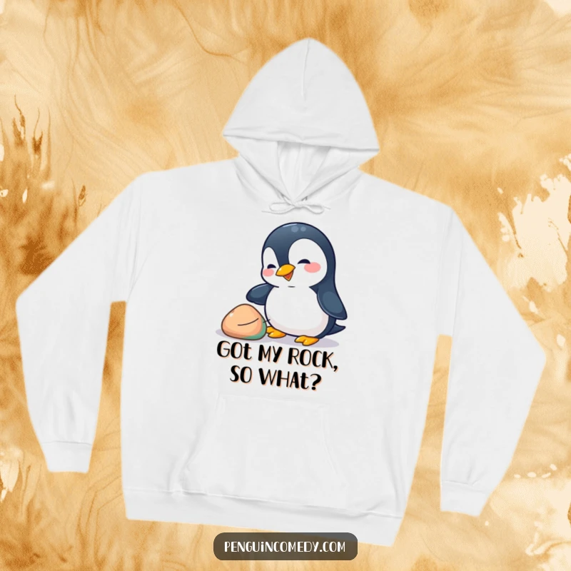 Funny penguin hoodie featuring a playful penguin nudging a colorful pebble with its beak, offering warmth and charming animal humor.