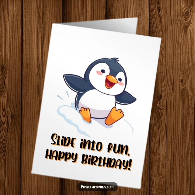 Funny free printable birthday card of a penguin joyfully sliding headfirst down a snowy slope with a gleeful expression.