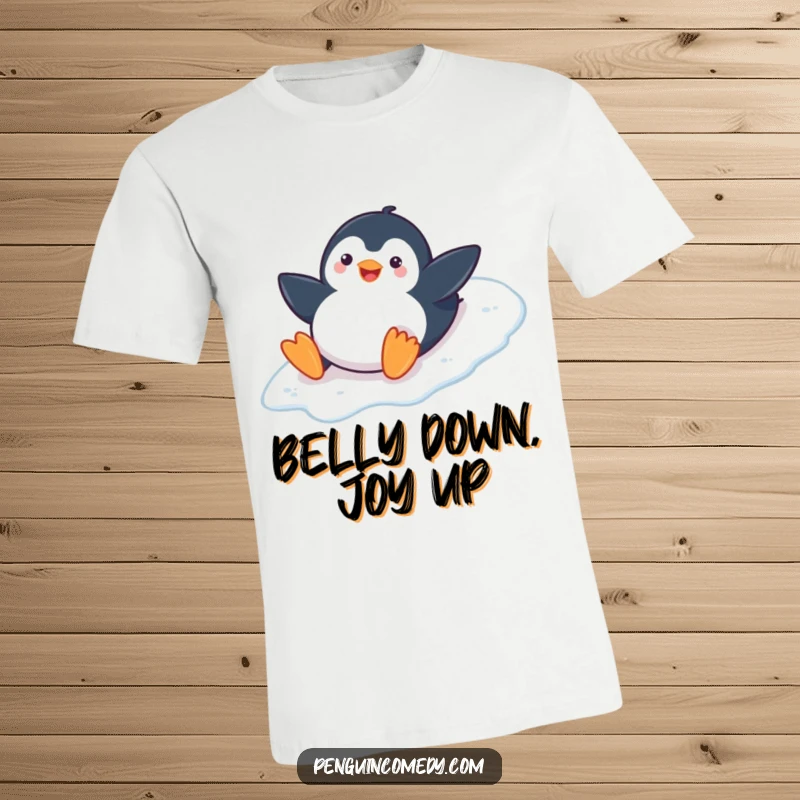 Funny Penguin Cotton T-Shirt: A happy penguin slides on its belly down an icy slope, embodying winter joy, a great funny gift.