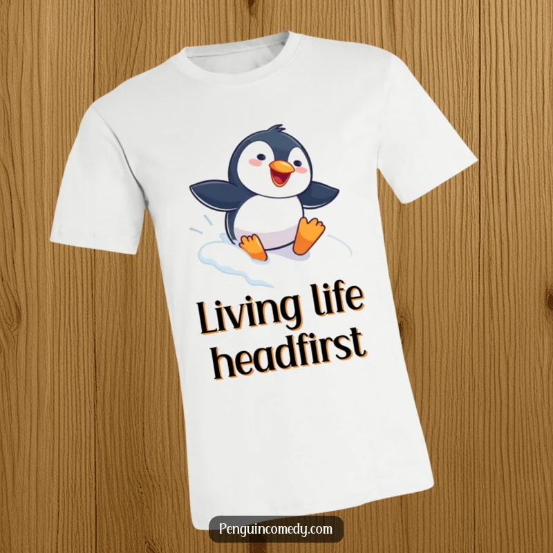 Funny Penguin T-Shirt depicting a gleeful penguin sliding headfirst down a snowy slope, symbolizing pure winter fun and uninhibited joy.