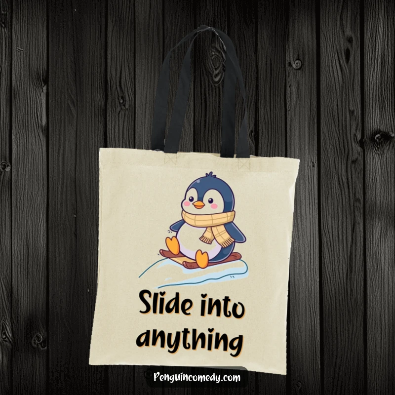 Funny tote bag featuring a cheerful penguin in a scarf, gleefully sliding down an ice-covered slope.